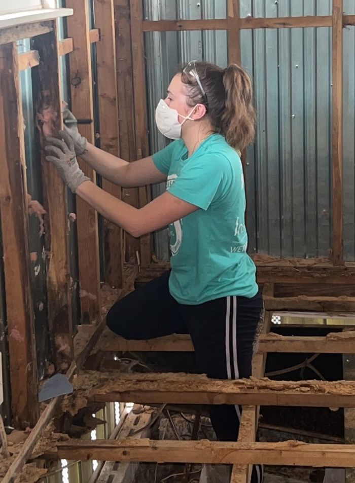 A Penn State Behrend student works in a damaged home in Fort Myers, Florida, during an Alternative Spring Break trip.