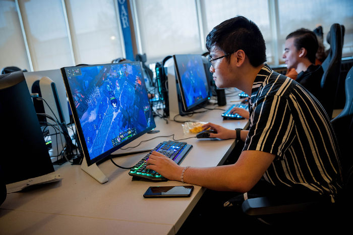 A male student plays a video game in Penn State Behrend's esports lounge.