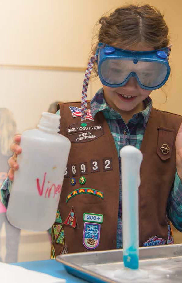 A Girl Scout works on an experiment on Behrend's Youth Education Outreach Scout day.
