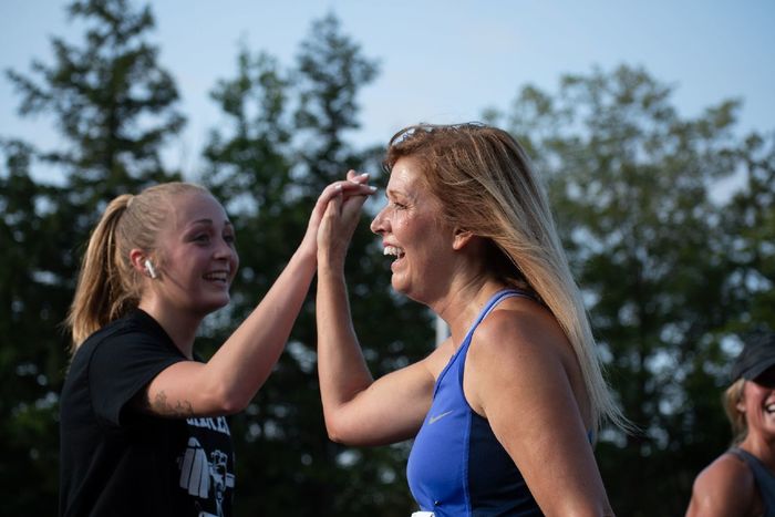 Two women high-five after the Run for Women at Penn State.