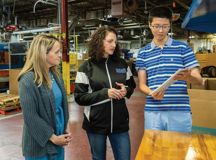From left, Dr. Ashley Yochim, associate teaching professor of English; Heather Evans ’98, human resources manager at Port Erie Plastics; and Behrend student Ming Xu, a Psychology major, discuss the multilingual signage project that students helped translate for the Harborcreek business.