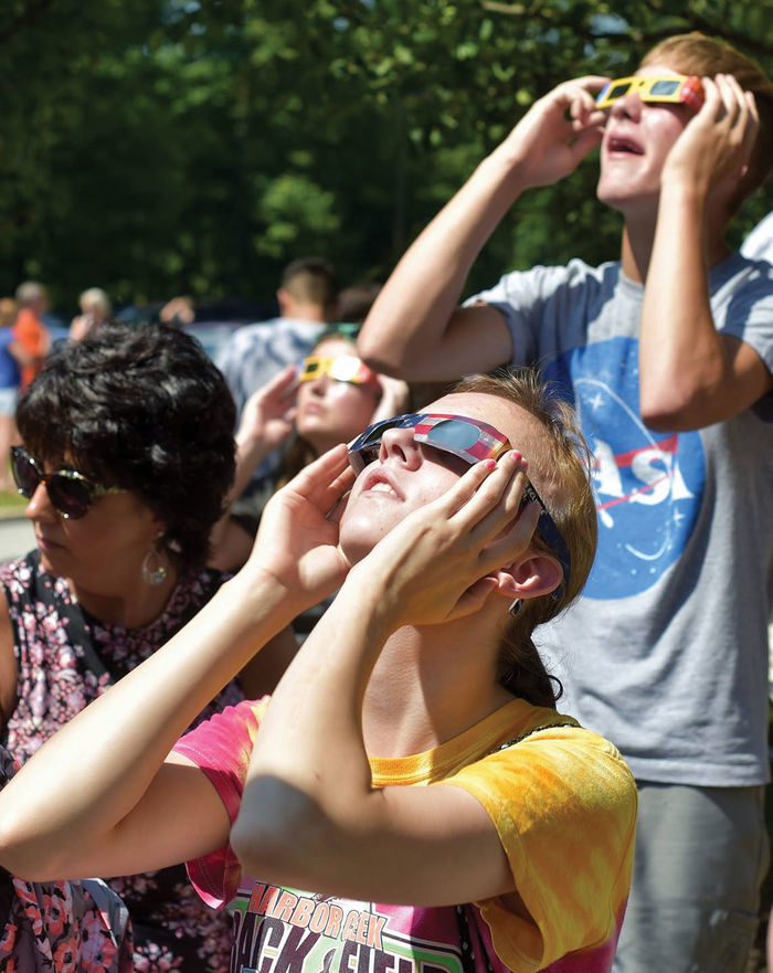 People watch the solar eclipse with safety glasses