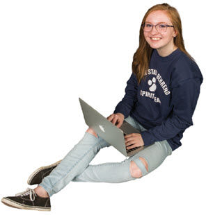 Female student sitting with laptop resting on her lap