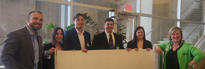 Photo of professionals and students standing in front of a window