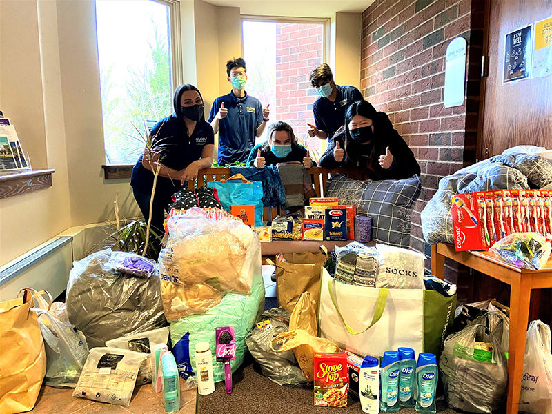 Students posing with items donations for refugees