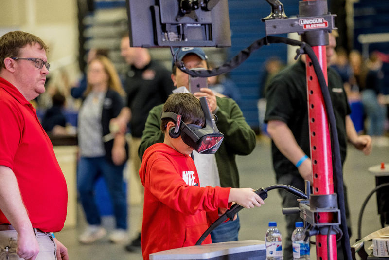 A boy tries a hands-on virtual welding simulation at the Penn State Behrend STEAM Fair.