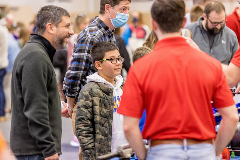 A boy and his father watch a science demonstration at the Penn State Behrend STEAM Fair.