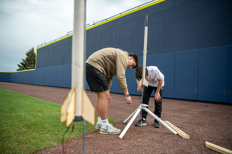 Two people prepare to launch rockets