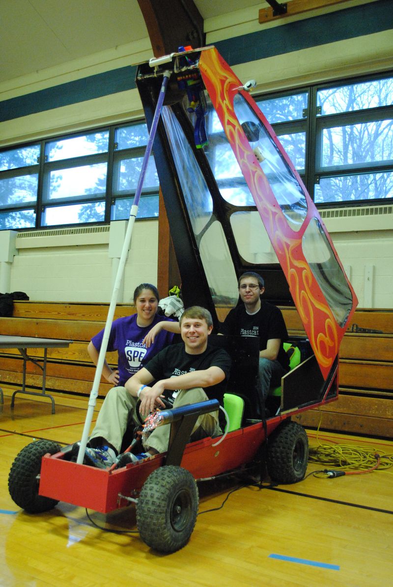 Penn State Behrend students pose with a model car.