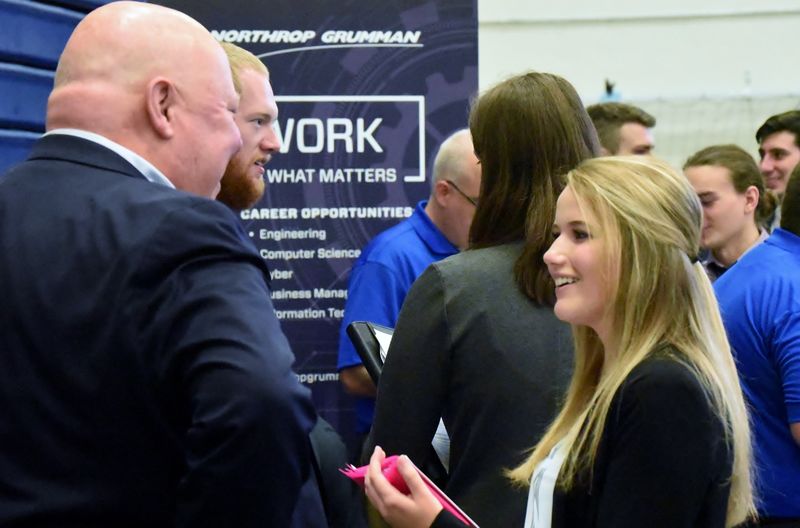 A student talks with a recruiter at the Penn State Behrend fall Career and Internship Fair.
