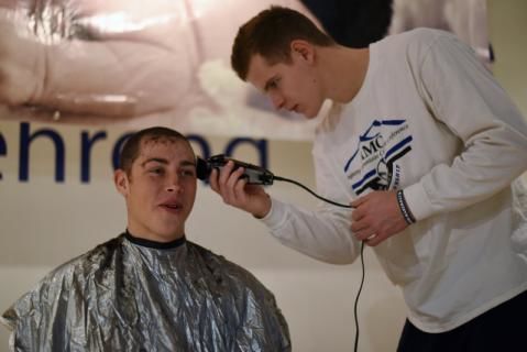 A Penn State Behrend baseball player has his hair cut.