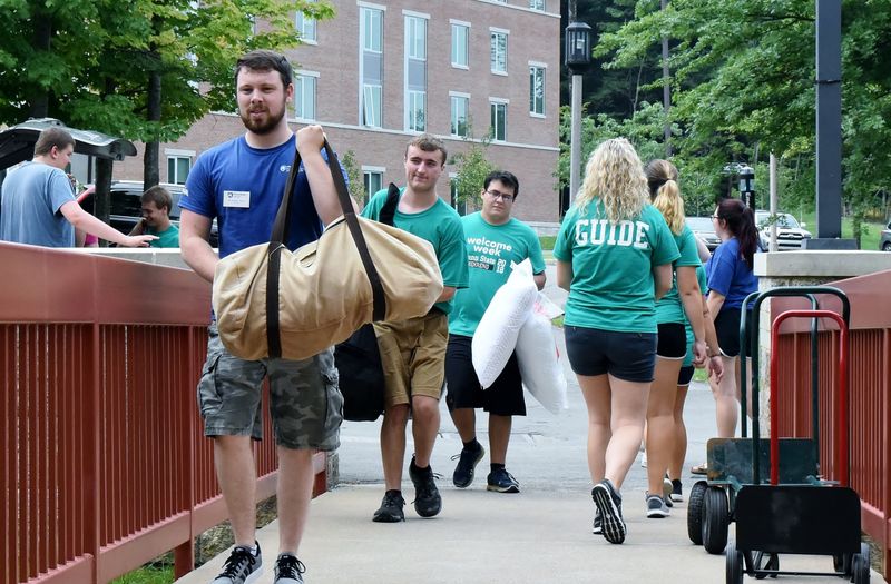 Students carry items into a residence hall at Penn State Behrend.