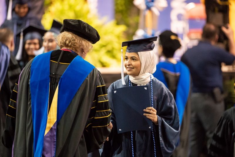 A student receives her degree at Penn State Behrend's spring commencement ceremony.