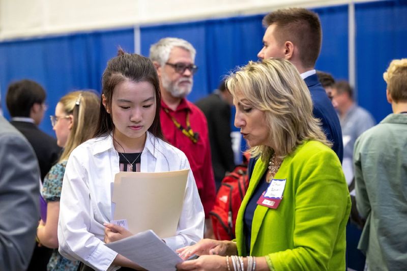 A female student talks with a corporate recruiter during Penn State Behrend's fall career fair.