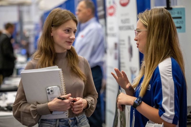 A female student talks with a corporate recruiter at Penn State Behrend's fall career fair.