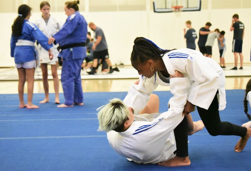 Two blind junior athletes practice judo moves on a mat at Penn State Behrend.