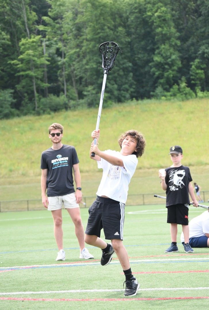 A blind junior athlete throws a lacrosse ball during a camp event at Penn State Behrend.