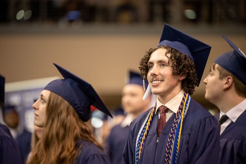 A graduate smiles during Penn State Behrend's spring commencement program.