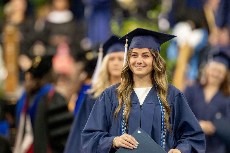 A graduate collects her diploma at Penn State Behrend's spring commencement program.
