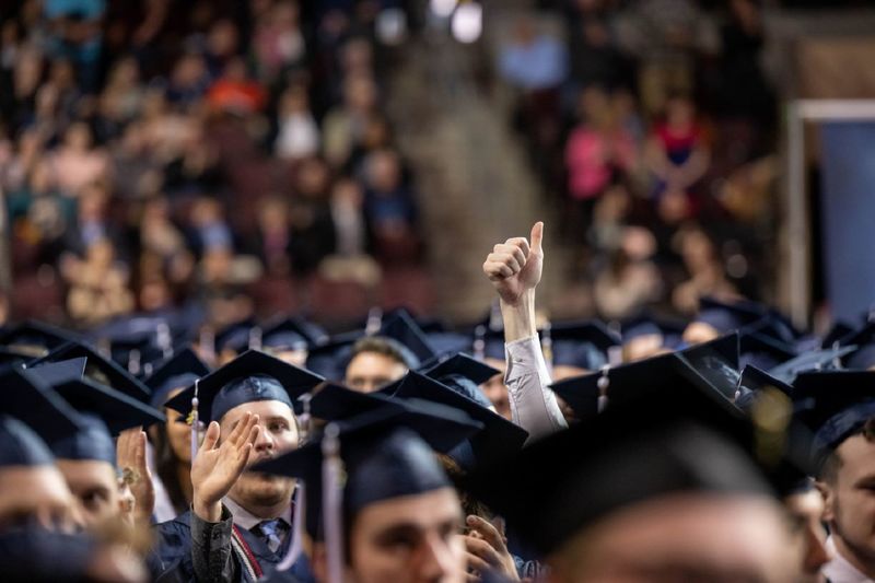 A new graduate gives the thumbs-up sign during Penn State Behrend's spring 2022 commencement ceremony.