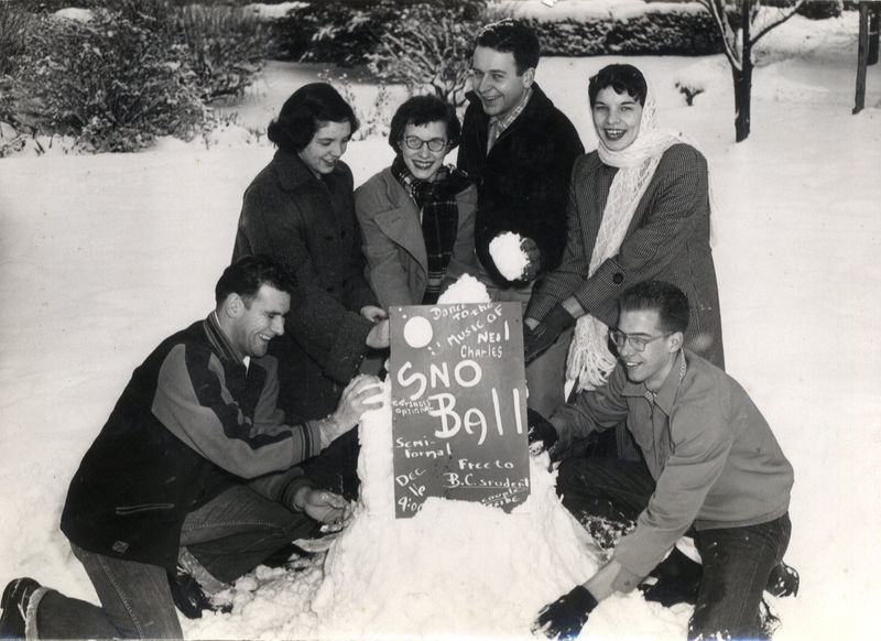 Students gather around a promotional sign for the Snow Ball dance at Behrend Center.