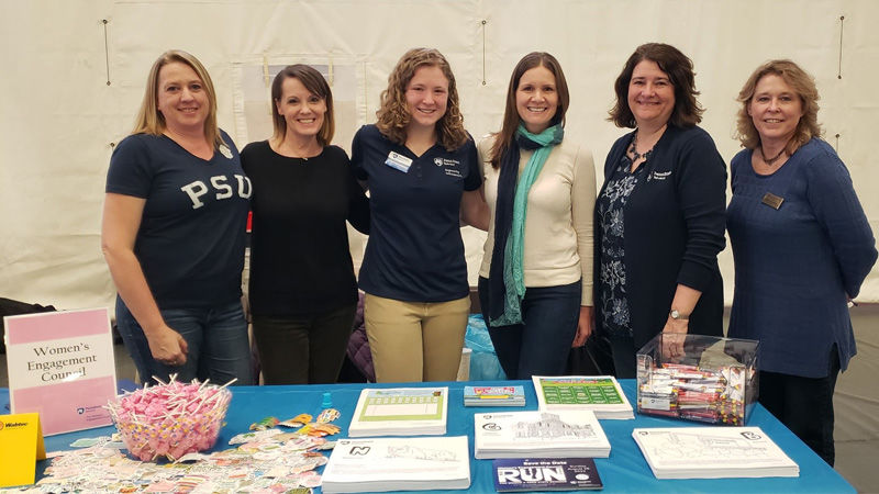 group of women behind a table at the Behrend STEAM Fair