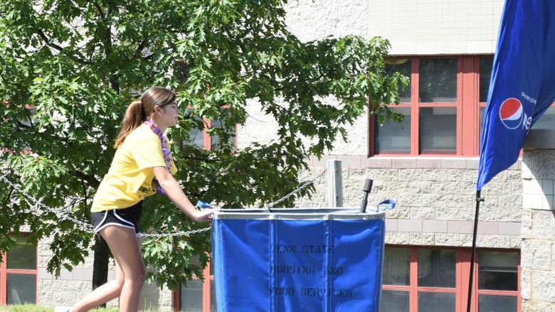 A female student pushes a luggage cart during Penn State Behrend's move-in day.