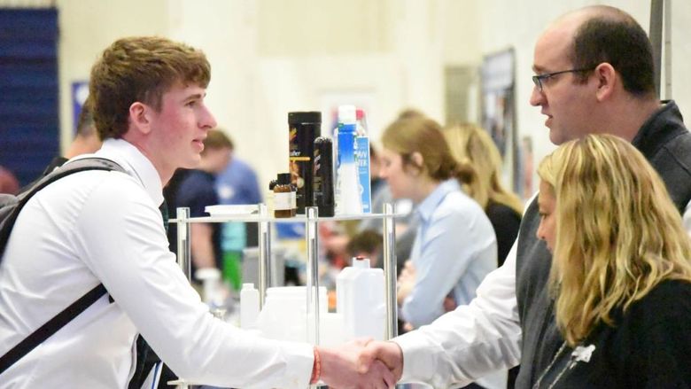 A student shakes hands with a corporate recruiter at Penn State Behrend's Career and Internship Fair.