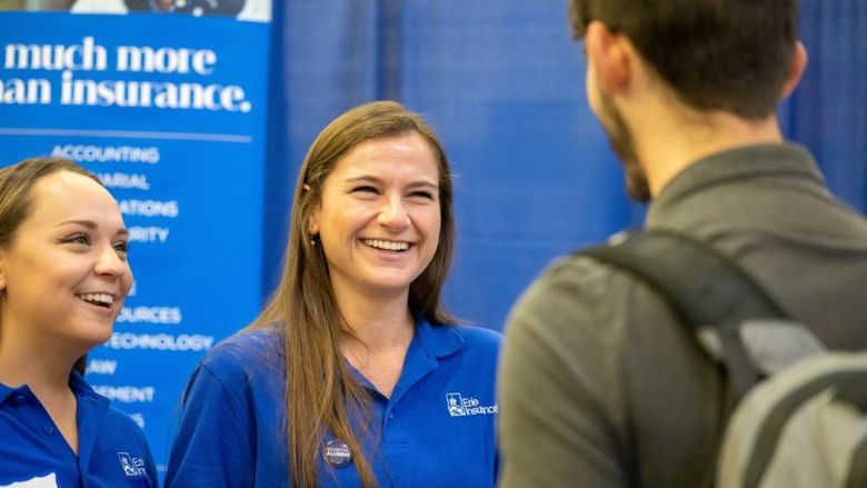 Two female corporate recruiters talk with a student during Penn State Behrend's fall career fair.