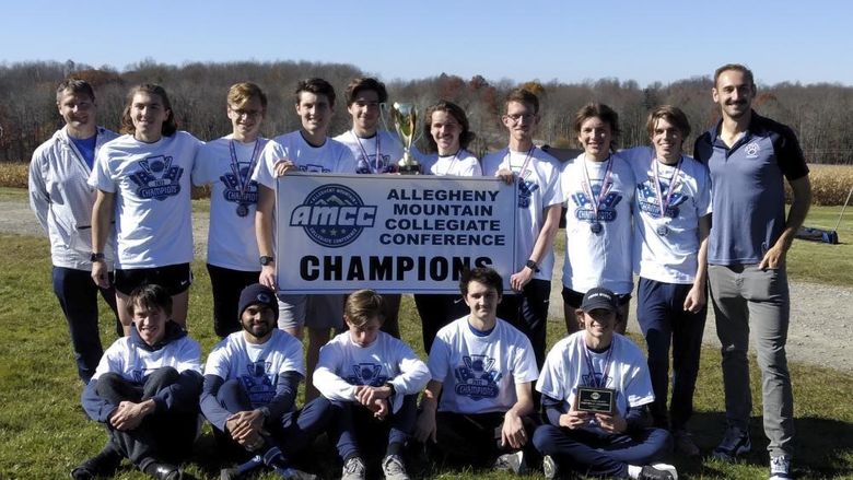 A group photo of the Penn State Behrend men's cross country team with an AMCC championship banner.
