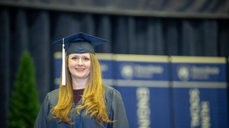 Brittany Anderson, a Penn State World Campus graduate who earned degrees in accounting and finance, poses before Penn State Behrend's December commencement program.