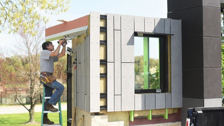 A contractor installs material on an architectural mockup at Penn State Behrend.