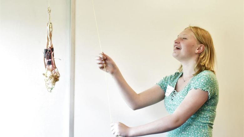 A female student drops a Barbie doll on a bungee cord at Penn State Behrend's Math Options Career Day.