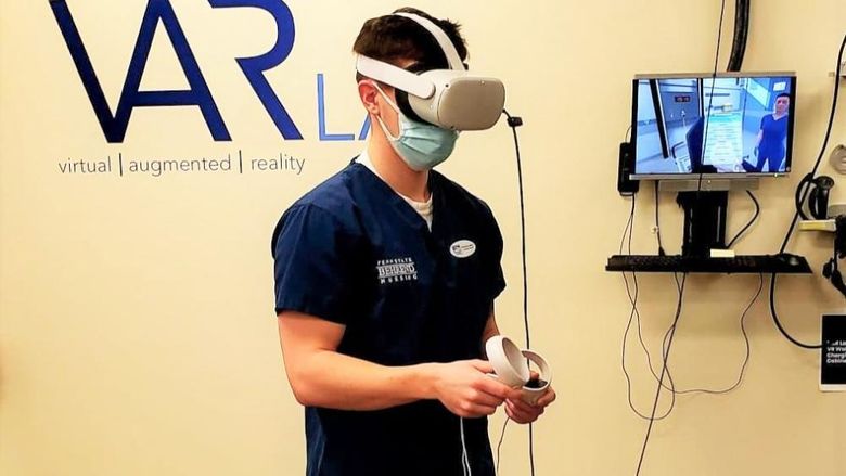 A male student in the nursing program at Penn State Behrend wears an Oculus headset while completing a VR simulation.