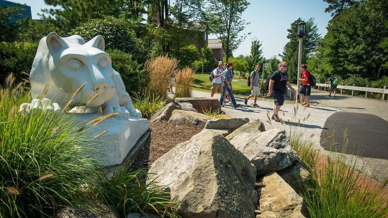 Students walk near the Nittany Lion shrine at Penn State Behrend
