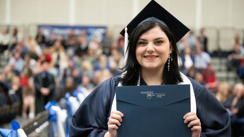 Penn State Behrend graduate Gabi Watson holds her diploma.