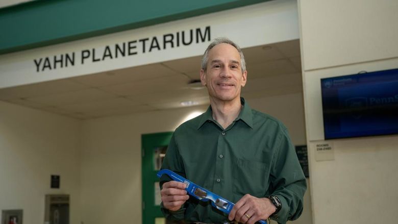 Planetarium director Jim Gavio holds a pair of eclipse glasses.