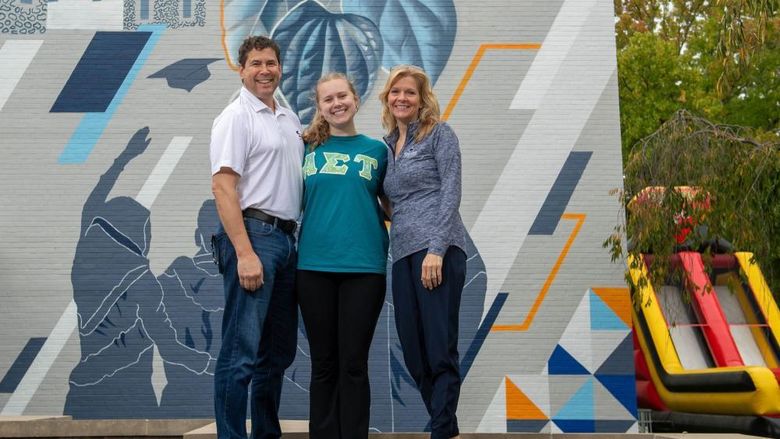 A student poses with her parents at Penn State Behrend's Parents, Families and Alumni Weekend.