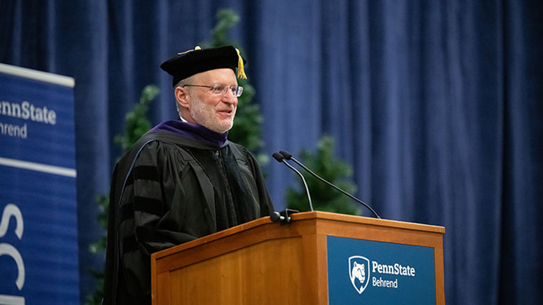 An alumnus addresses graduates at commencement