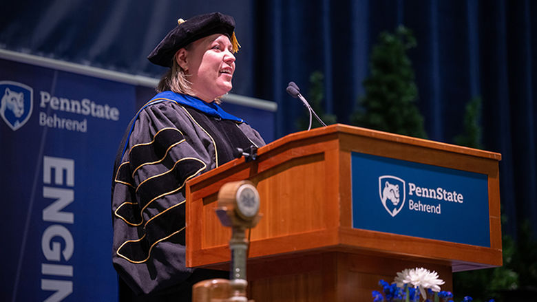 A professor speaks to graduates during commencement