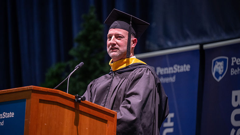 An alumnus addresses graduates during the commencement ceremony