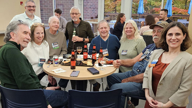 Alumni gathering around a table