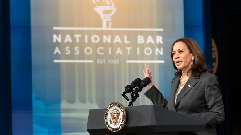 Kamala Harris at a podium with a National Bar Association banner in the background