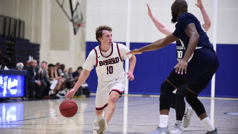 Penn State Behrend basketball player Andy Niland dribbles the ball.