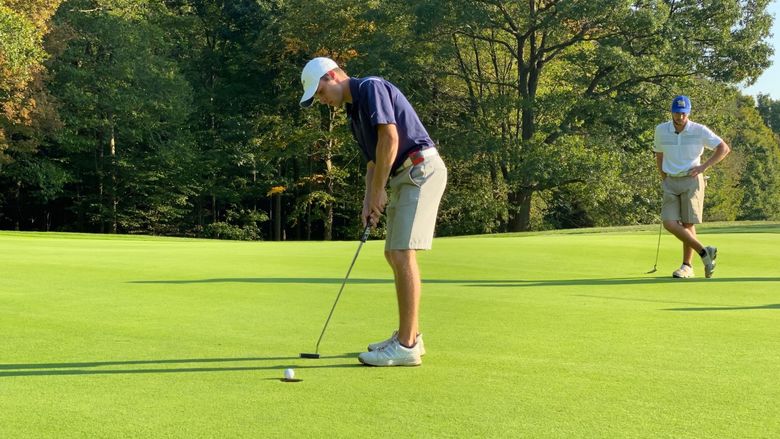 A Penn State Behrend golfer attempts a putt.