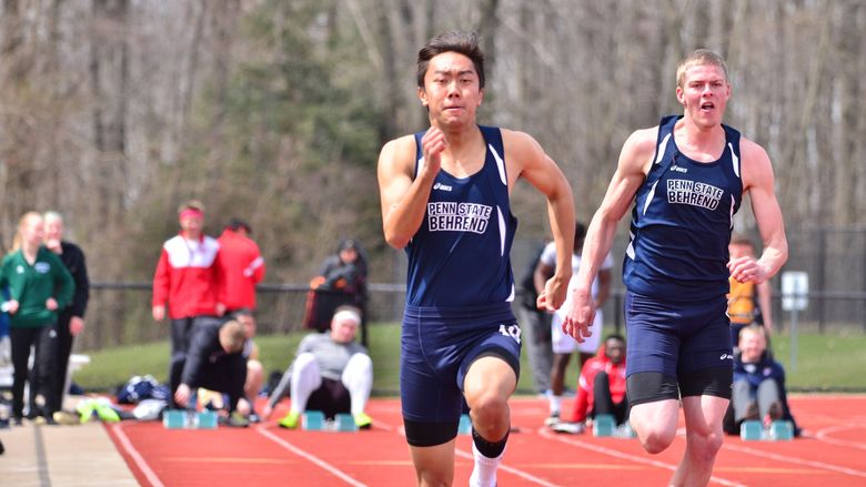 Two Penn State Behrend runners race on an outdoor track.