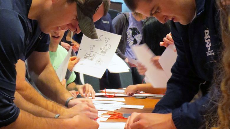 Students assemble coloring books during a service project at Penn State Behrend.