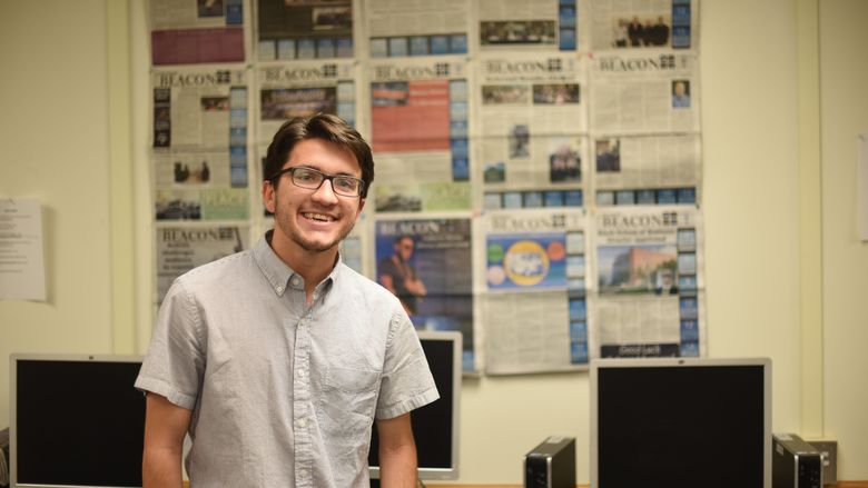 Josh Kolarac stands in front of a display of Behrend Beacon newspapers.