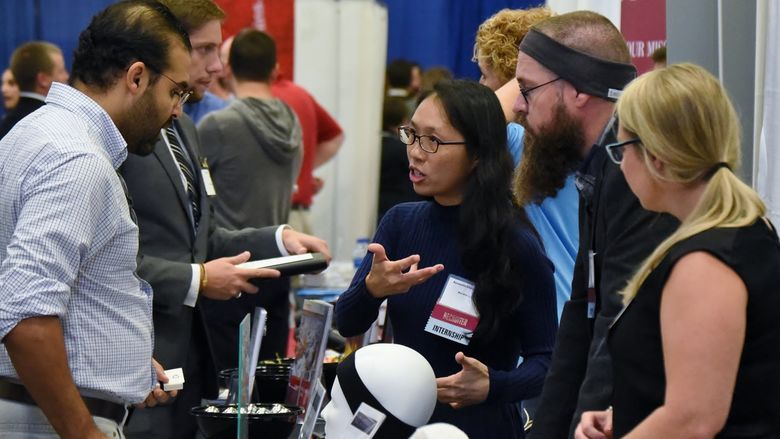 AcousticSheep LLC CEO Wei-Shin Lai, center, meets with a student during Penn State Behrend's Fall Career and Internship Fair, held Sept. 19 at the college.