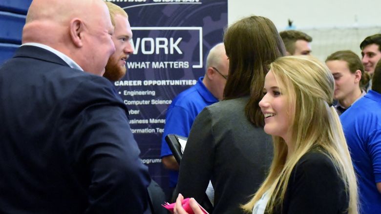 A student talks with a recruiter at the Penn State Behrend fall Career and Internship Fair.